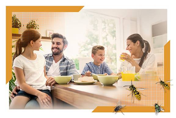 Familie sitzt glücklich am Tisch und ist vor Insekten geschützt